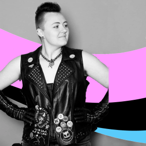 a black and white picture of Rylee, an androgynous light-skinned person in a mohawk and a studded leather jacket.